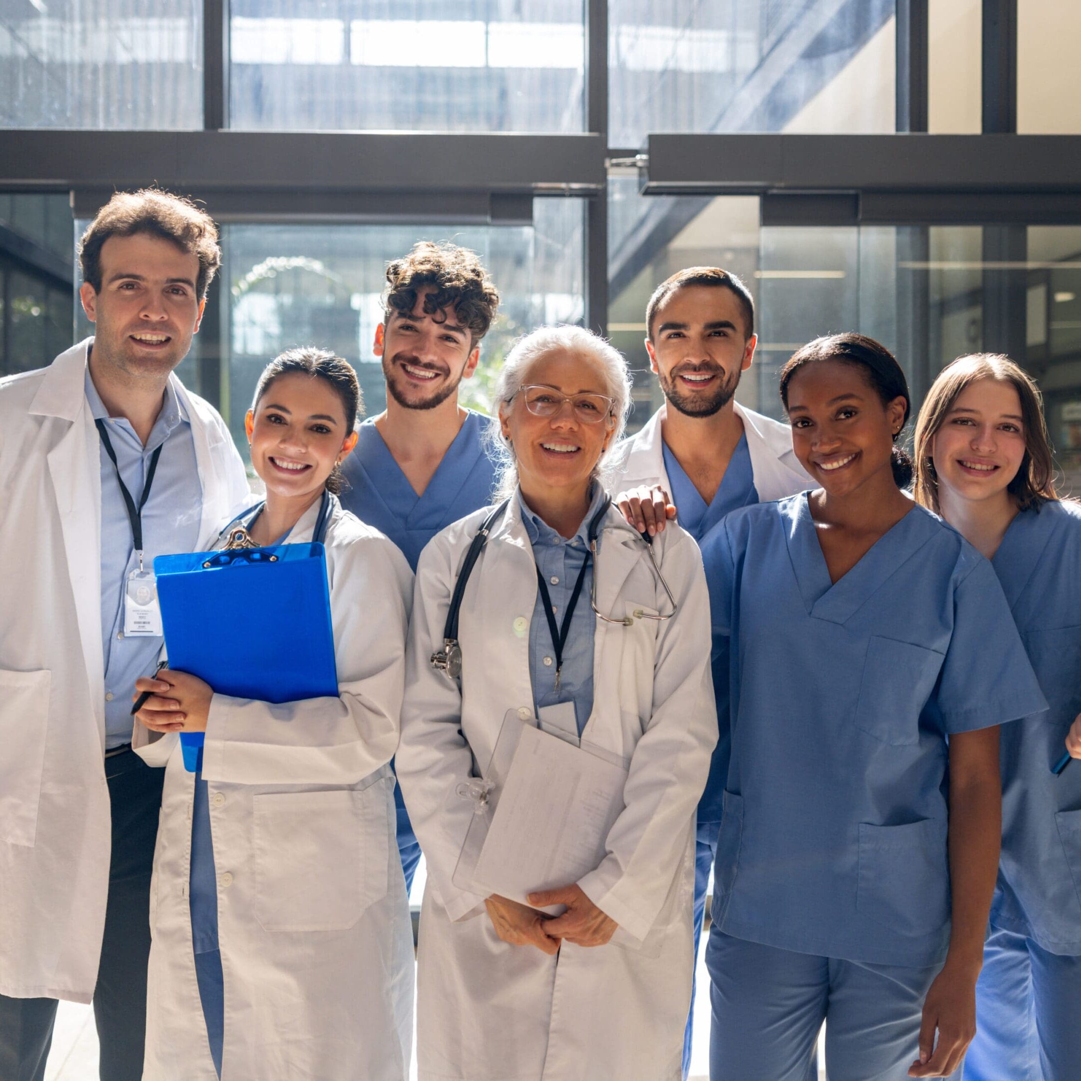 A diverse group of medical professionals posing confidently in a hospital.